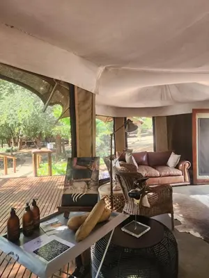 a living room with a couch and a table at Karongwe - Chisomo Safari Camp in Hoedspruit