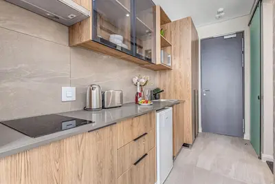 a kitchen with wooden cabinets and a counter top at StayCeity at Menlyn Maine in Pretoria