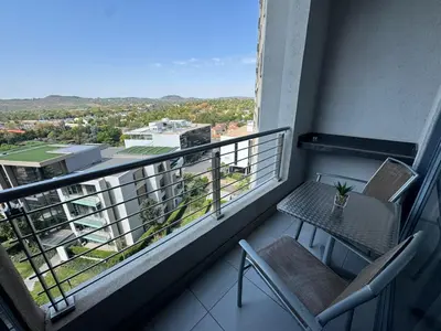 a balcony with a table and chairs on a building at Menlyn Maine Residences 813 in Pretoria