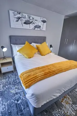 a bedroom with a large bed with yellow pillows at Spacious Fully Equipped Studio - Peaceful-Free WiFi in Pretoria