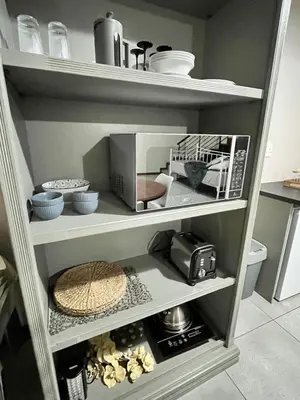 a kitchen shelf with a toaster oven and other kitchen items at Grace541 in Pretoria