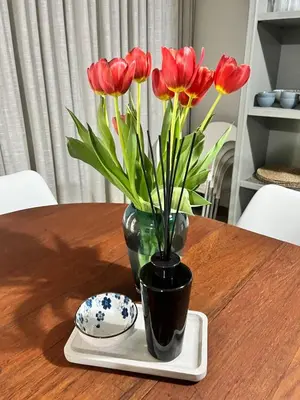 a vase with red flowers sitting on a table at Grace541 in Pretoria