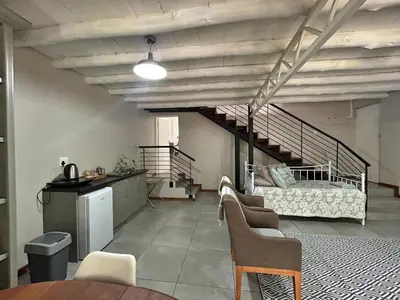 a living room with a staircase and a couch at Grace541 in Pretoria
