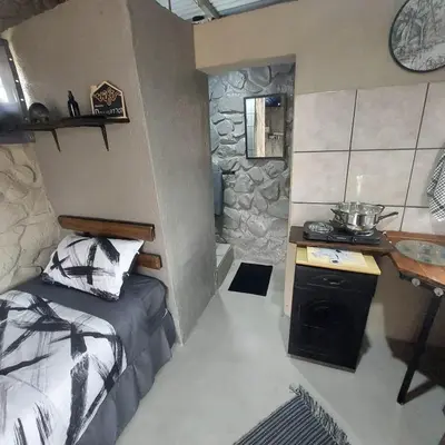 a small room with a bed and a sink in it at Wegpak in Barberton