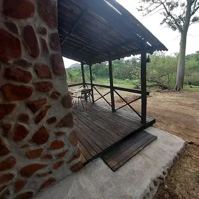 a building with a wooden deck with a roof at Wegpak in Barberton