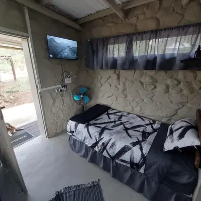 a bedroom with a bed and a tv on the wall at Wegpak in Barberton