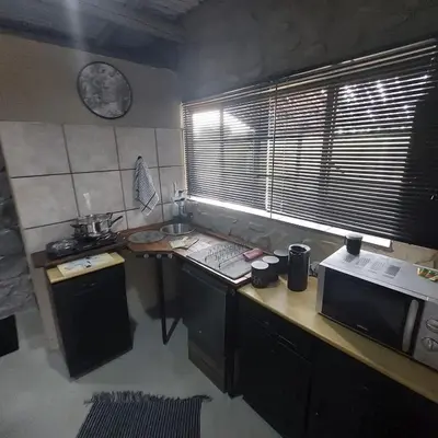 a kitchen with a counter with a microwave and a window at Wegpak in Barberton