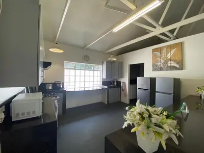 a large kitchen with a vase of flowers on a table at Fiet Star in Midrand