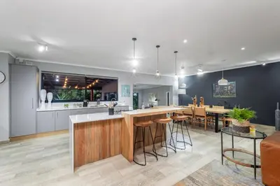 an open kitchen and living room with a bar with stools at Bird of Paradise in Tzaneen