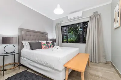 a bedroom with a white bed and a window at Bird of Paradise in Tzaneen
