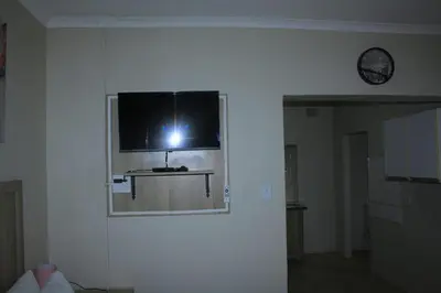 a person taking a picture of a television on a wall at Zonke Bonke Guest House Lydenburg in Lydenburg