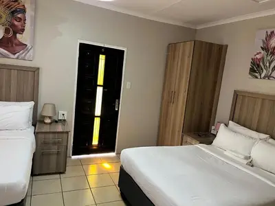 a bedroom with two beds and a door to a window at Zonke Bonke Guest House Lydenburg in Lydenburg