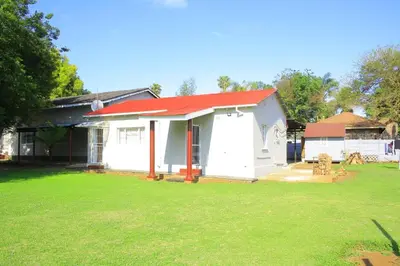 a small white house with a red roof at Zonke Bonke Guest House Lydenburg in Lydenburg