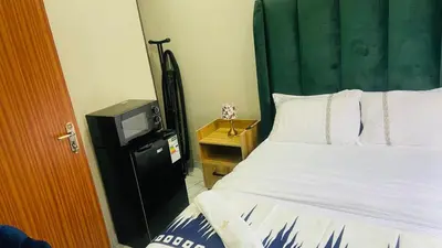 a bedroom with a bed and a television at Crown Palace Guesthouse in Pretoria