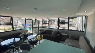 a living room with a couch and a table and chairs at Crown Palace Guesthouse in Pretoria