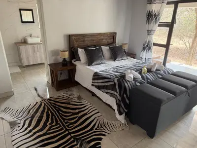 a bedroom with a bed and a zebra rug at Elephant Rest in Marloth Park