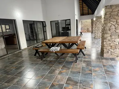 a dining room with a wooden table and benches at Elephant Rest in Marloth Park
