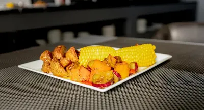 a plate of food with corn on a table at Khayalami Hotel - Secunda in Secunda