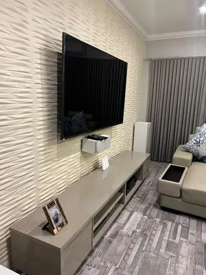 a living room with a large television on a wall at oliphant private House in Midrand