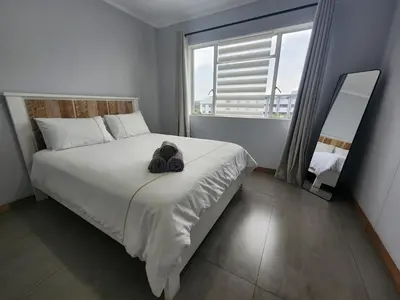 a bedroom with a bed with a pair of shoes on it at Vista Retreat - Stylish Flat at Menlyn Main in Pretoria