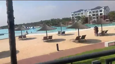 a beach with chairs and umbrellas on a beach at The Blyde Crystal Lagoon in Pretoria