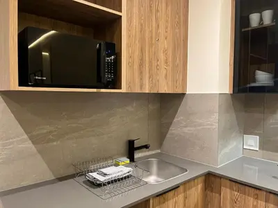 a kitchen with a sink and a microwave at Luxury King Studio, Menlyn Maine, Time Square Views, Smart Access in Pretoria
