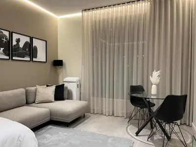 a living room with a couch and a table at Luxury King Studio, Menlyn Maine, Time Square Views, Smart Access in Pretoria