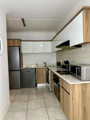 a large kitchen with white cabinets and appliances at DreamStay The Blyde Pretoria in Pretoria