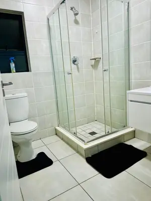a bathroom with a shower and a toilet and a sink at DreamStay The Blyde Pretoria in Pretoria