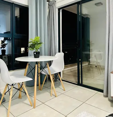 a table and chairs in a room with a balcony at DreamStay The Blyde Pretoria in Pretoria