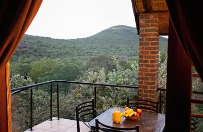 a table with a bowl of fruit on top of a balcony at Mabalingwe in Bela-Bela
