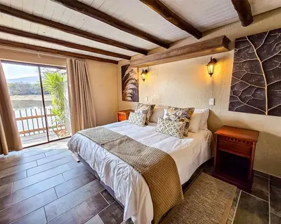 a bedroom with a bed and a large window at Mabalingwe in Bela-Bela