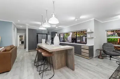 a kitchen with a counter and a living room at Honeysuckle in Tzaneen