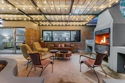 a living room with a fireplace and a couch at Honeysuckle in Tzaneen