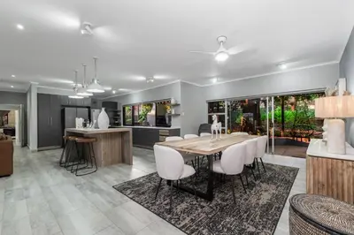 a kitchen and dining room with a table and chairs at Honeysuckle in Tzaneen