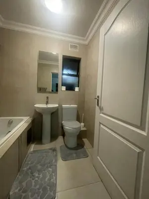 a bathroom with a white toilet and a sink at Horizon Retreat in Midrand