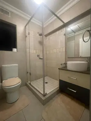 a bathroom with a shower and a toilet and a sink at Horizon Retreat in Midrand