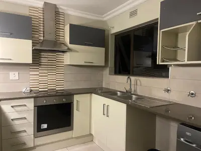 a kitchen with white cabinets and a sink at Horizon Retreat in Midrand