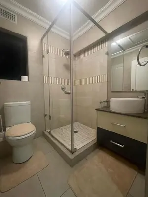 a bathroom with a shower and a toilet and a sink at Horizon Retreat in Midrand