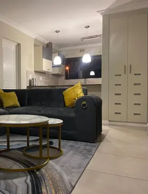 a living room with a black couch and a table at Horizon Retreat in Midrand