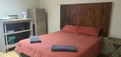 a bedroom with a bed with a red bedspread at 329 on 30th Avenue Villieria Ashleigh in Pretoria