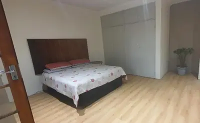 a bedroom with a large bed with red pillows on it at 329 on 30th Avenue Villieria Ashleigh in Pretoria