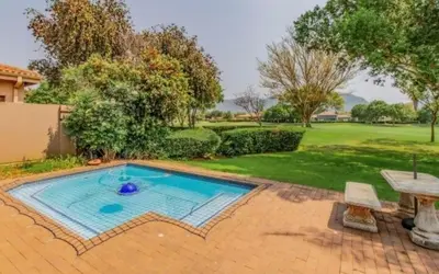 a small swimming pool in a yard with a table at Pecanwood Haven Hartbeesport Dam in Hartbeespoort