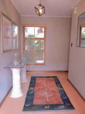 a living room with a table and a rug at Pecanwood Haven Hartbeesport Dam in Hartbeespoort