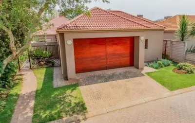 a house with a red garage door in a yard at Pecanwood Haven Hartbeesport Dam in Hartbeespoort