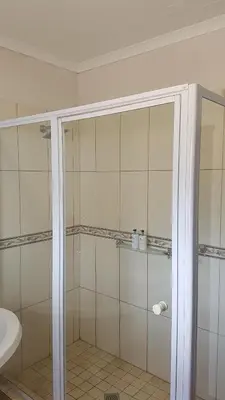 a bathroom with a shower with a glass door at Art Gallery Guest House in Haenertsburg