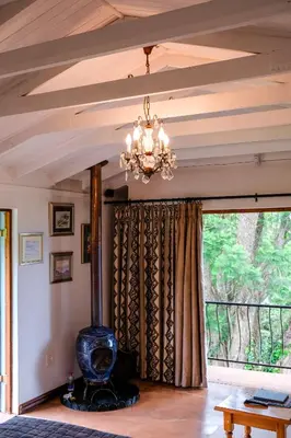 a chandelier in a living room with a large window at Art Gallery Guest House in Haenertsburg