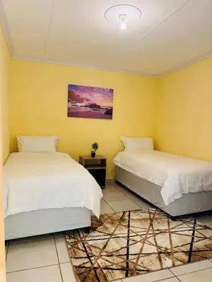 two beds in a room with yellow walls at Cozy Hideout near Kruger in Hectorspruit