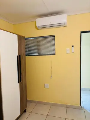 a room with a yellow wall and a air conditioner at Cozy Hideout near Kruger in Hectorspruit