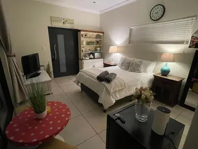 a bedroom with a bed with a clock on the wall at The Mush Room in Centurion